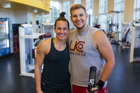 male and female in workout apparel posing in fitness center